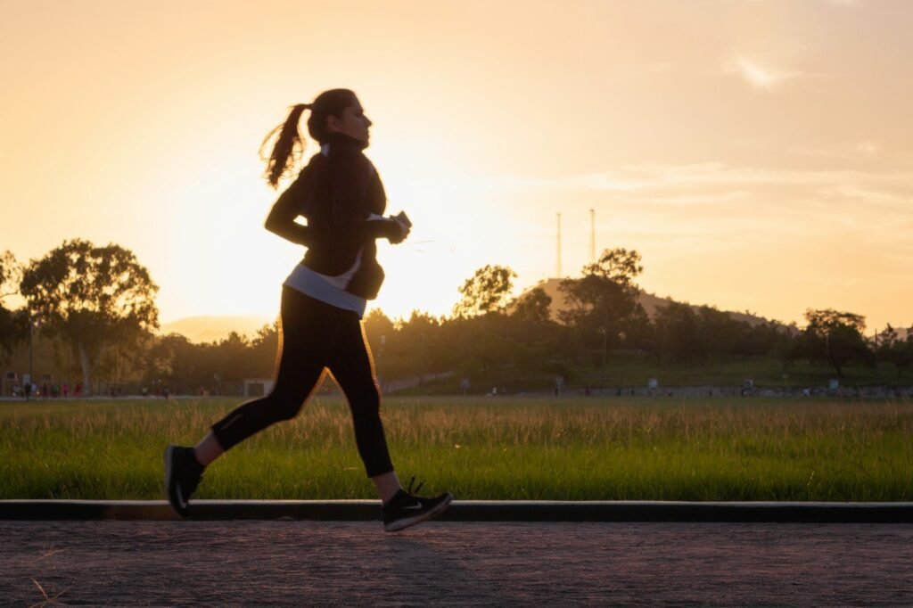 woman in black sports bra and black pants running on water during sunset, fitness