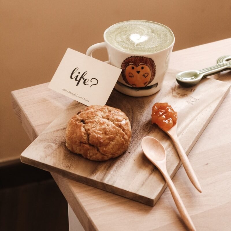 life insurance, white ceramic mug beside brown cookies on brown wooden chopping board