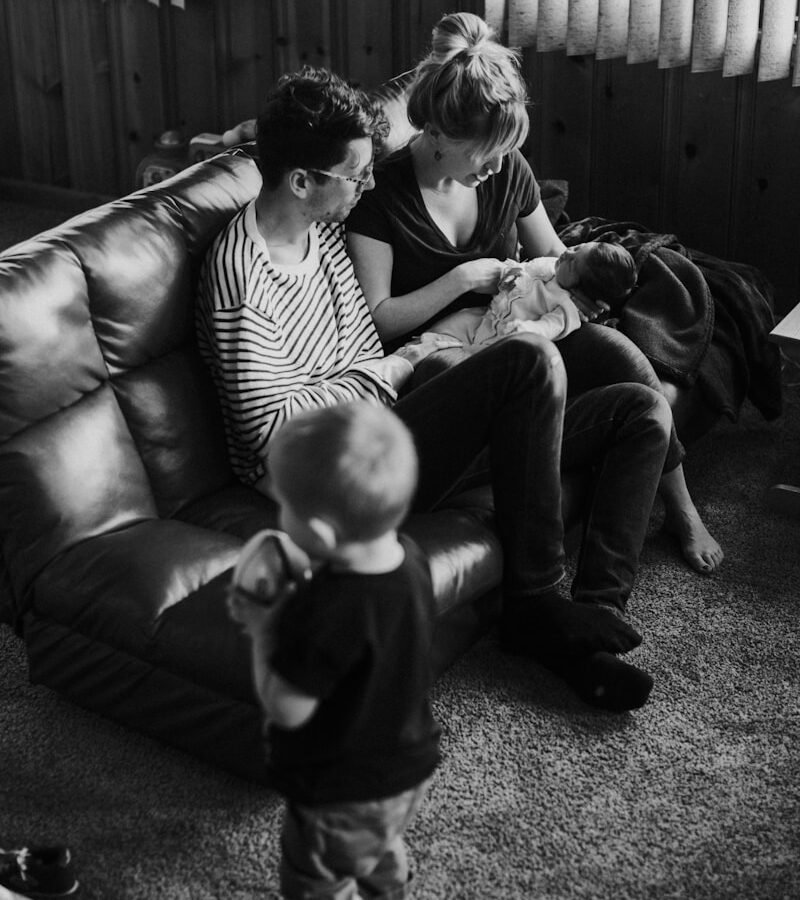 life insurance, grayscale man and woman sitting on couch carrying baby