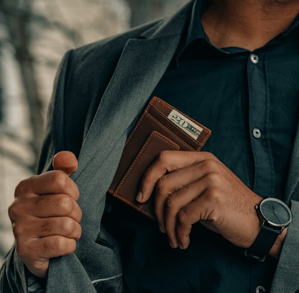 financial laws. a man holding a wallet and a watch