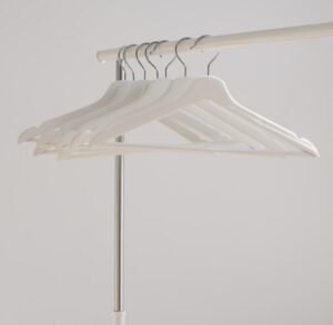 white clothes hangers hanging on rack, dressing and personality